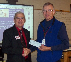 In December, Terry Watkins (l), chapter chair for the Education Committee, presents Michael J. Minnema, Baptist Hill High School, with a $1000 grant to help the school procure miscellaneous laboratory equipment.